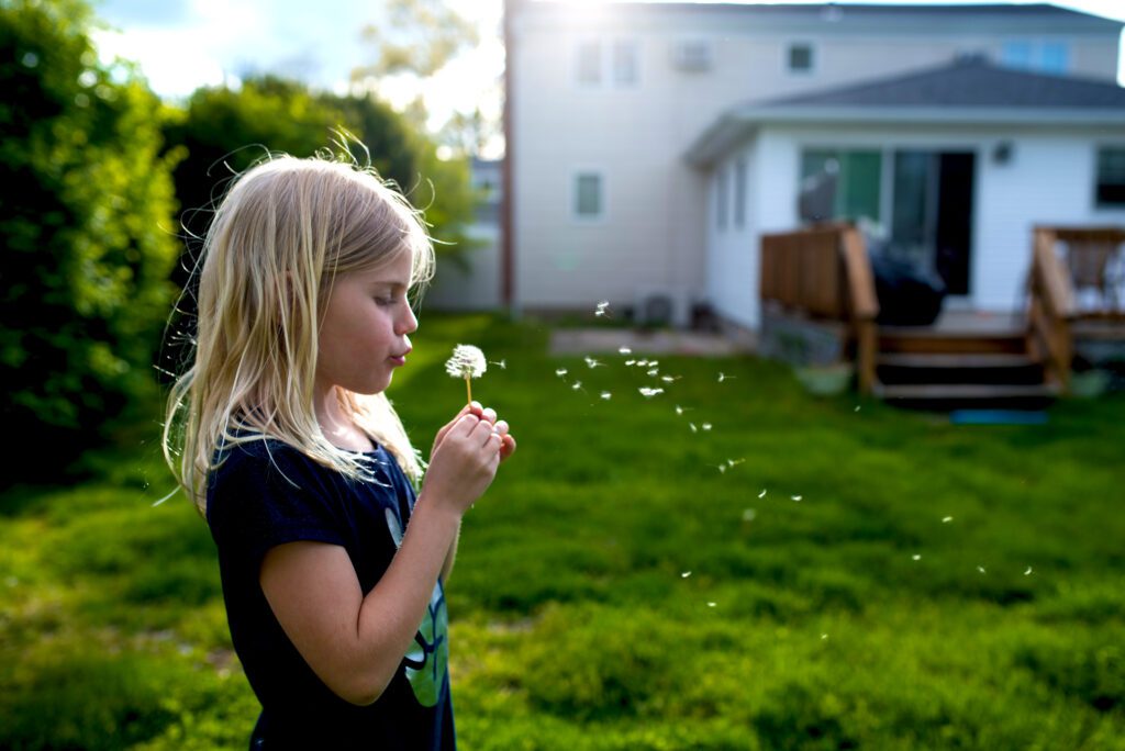 young girl blowing flower shareourstrength.org
