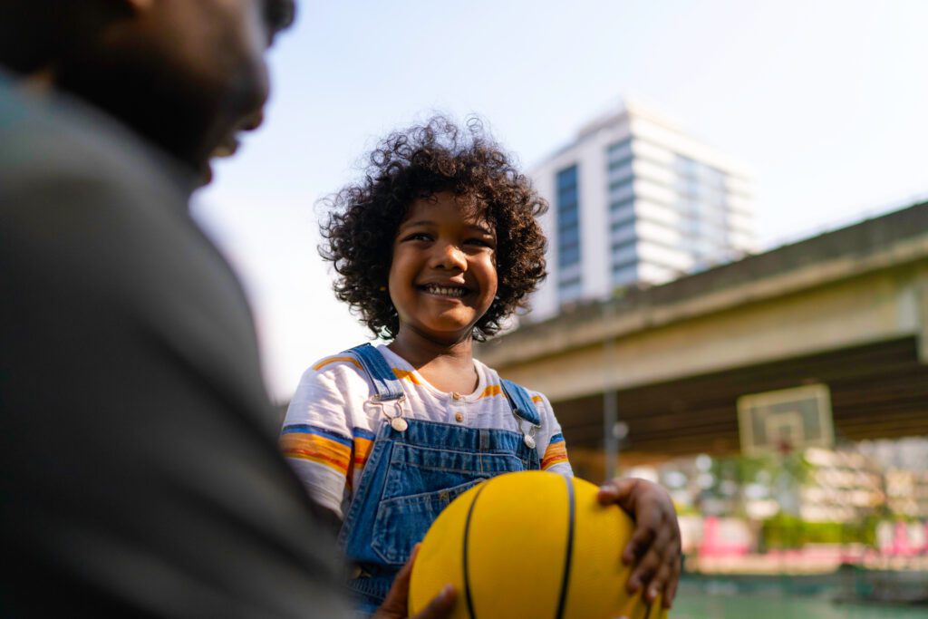 child holding ball in city