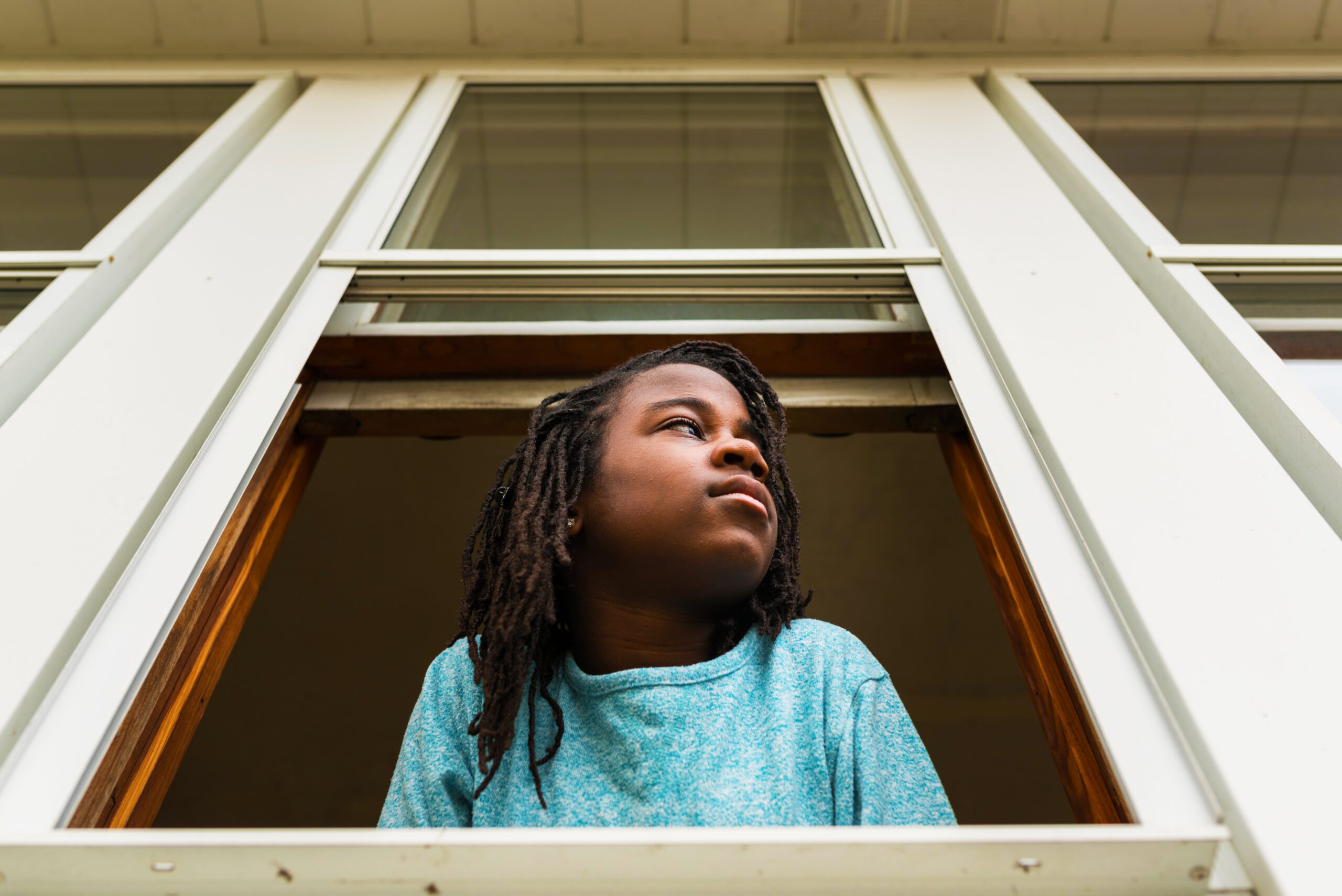 young african american girl staring out window