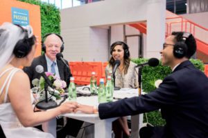 Four people speaking outside with a wedding gown